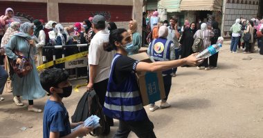 متطوعون شباب يوزعون زجاجات المياه والكمامات على طلبة الثانوية بالغربية.. صور