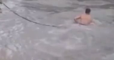 رجل شرطة صينى يقوم بعمل بطولى وينقذ شخص جرفته السيول.. فيديو