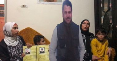 زوجة وأطفال شهيد شرطة بشمال سيناء يصنعون مجسما يحمل صورته.. صور