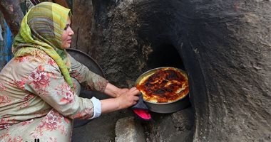 صورة اليوم.. محلاها عيشة الفلاحة.. سيدة ريفية تطهو الرز المعمر فى فرن فلاحى