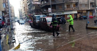 الإسكندرية قبل وبعد النوة.. رجال المرور يساعدون قائدى السيارات خلال الأمطار