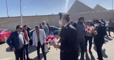 رجال الشرطة يحتفلون بعيدهم ويوزعون أوراق البردى على السائحين أمام الأهرامات