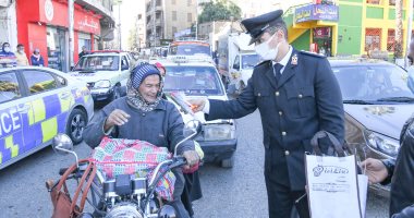 ضباط مرور قنا يوزعون الورود على سائقى السيارات والمواطنين بمناسبة عيد الشرطة.. صور