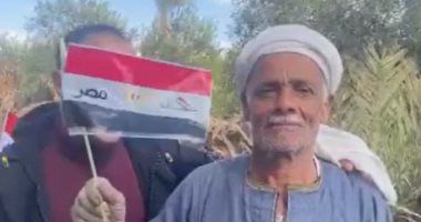 شاب من ذوى الهمم يوزع أعلام مصر على الأهالى فى المنيا قبل نهائى أمم أفريقيا