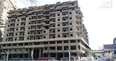 حكاية أشهر عمارة مهجورة بالجيزة.. توقف البناء بها عند 10 أدوار من 30 سنة.. تطل على محطتى المترو والقطار ويسكنها الخارجون عن القانون.. والأهالى: السرقات تكثر بمحيطها والبعض استولى على شقق ويسكنها.. صور