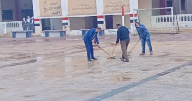 مدير مدرسة يساعد العمال فى رفع مياه الأمطار بفناء إحدى مدارس كفر الشيخ