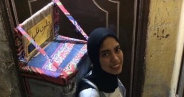 "عليا" تحمل جاليرى متنقل على ظهرها وتجوب الشوارع لعرض إبداعاتها على المارة