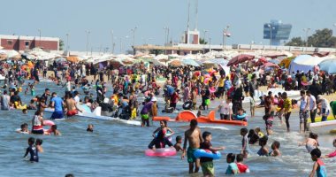 المصطافون يتوافدون على شاطئ بور فؤاد هربا من موجة الحر.. صور