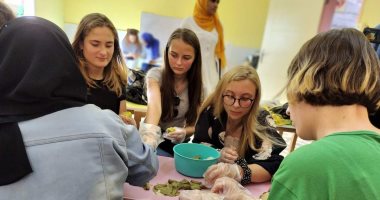 شباب وفتيات ألمانيا يشاركون بتجهيز "الملوخية والمحشى" فى الأقصر.. صور
