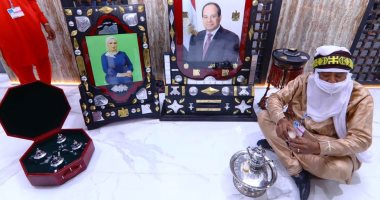 الحسين شيخو سفير الثقافة بالعالم يفترش الجناح المصرى بجوار صورة الرئيس السيسى