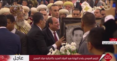 الرئيس السيسي يوقع على صورة لأحد الحاضرين بقداس عيد الميلاد المجيد