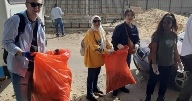 طاقم أكبر مكتبة عائمة بالعالم ينظفون شارع فلسطين فى بورسعيد.. صور 