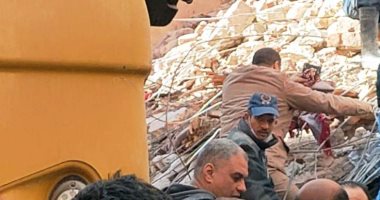 انتشال جثة سيدة تحتضن المصحف على سجادة الصلاة أسفل عقار أسيوط المنهار.. صور