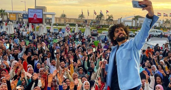 من بلكونة بيته لمعرض الكتاب.. محمد عادل يعزف لعشاق القراءة