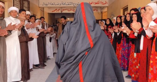 معلمون بسيناء ينظمون ممرا شرفيا لزميلتهم وهى ترتدى الثوب البدوى يوم بلوغها المعاش