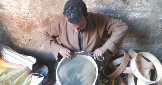 "ينخلون الزرق بالغربال".. حكاية شباب يعملون فى الصنعة وراثة عن آبائهم منذ 25 عامًا بقنا.. أحد الصناع: الغربال تراث لا غنى عنه فى المنزل وأستغرق 3 دقائق فى القطعة.. وآخر يؤكد: نجوب القرى والمدن للبيع.. صور