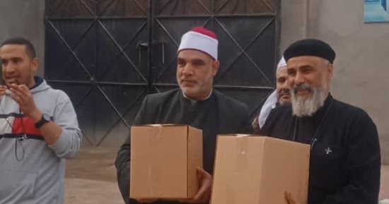 كاهن كنيسة بالإسكندرية يشارك فى توزيع صكوك إطعام مع الأوقاف 