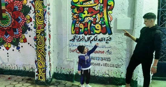 رمضان فى مصر حاجة تانية.. فنان تشكيلى يحول شارعه فى شبرا الخيمة للوحة جمالية.. "بكار وحسونة وفنانيس" أبرز الرسومات.. و"الله أكبر.. الله محبة" على منازل المسلمين والمسيحيين.. يؤكد: المبادرة بالجهود الذاتية.. صور