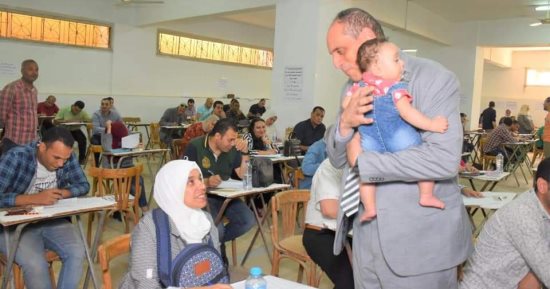 عميد تجارة طنطا يحمل طفلة إحدى طالبات الدراسات العليا أثناء أدائها الامتحان
