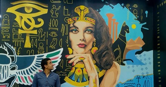 "أحمد" زين شوارع بورسعيد بجدارية ضخمة بروح فرعونية مرسومة بطريقة معاصرة