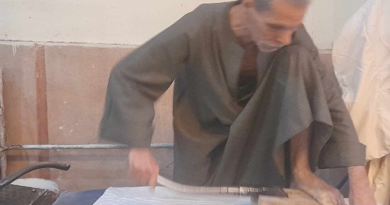 حكاية "بدرى" مع أقدم مكواة رجل فى قنا: ورثتها عن والدى وتحتاج إلى القوة والصبر