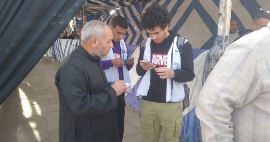 متطوعون يساعدون المسنين لمعرفة أماكن اللجان الانتخابية بالعاشر من رمضان.. صور