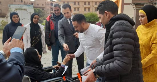 رئيس لجنة يخرج لمساعدة عجوز للإدلاء بصوتها فى انتخابات الرئاسة بالدقى.. صور 