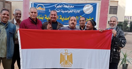 الناخبون فى لجان المغتربين بالحوامدية يرفعون علم مصر خلال الإدلاء بأصواتهم