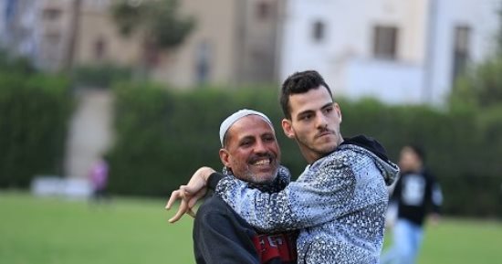 سنده في الدنيا وسر ابتسامته.. عم محمد يحمل ابنه الشاب ذوى الهمم ليشاهد المباراة