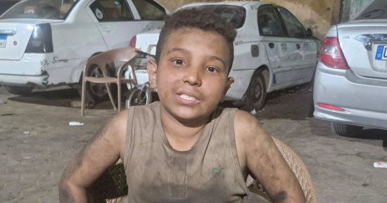 طفل تحت العربية وحلمه فوق السحاب.. محمود أصغر ميكانيكى فى الشرابية يعيل أسرة ويحلم بمقعد فى المدرسة.. يعمل 8 ساعات يوميا ليؤمن لقمة عيش لوالديه وشقيقتين.. ويخفى ملابسه "المشحمة" عن أعين أصدقائه: بيعايرونى بيها