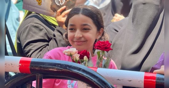 طفلة تنتظر شقيقتها بالورود أمام لجان الثانوية العامة فى الجيزة