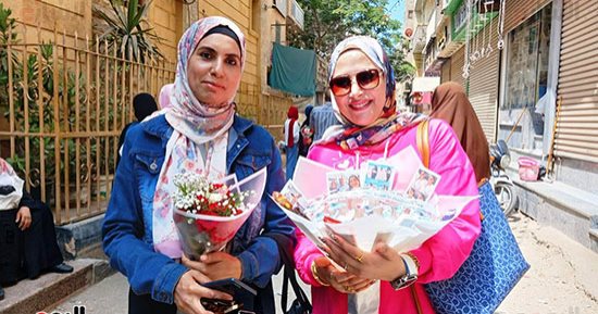 بالورود.. الأمهات ينتظرن بناتهن طالبات الثانوية العامة أمام اللجان.. صور
