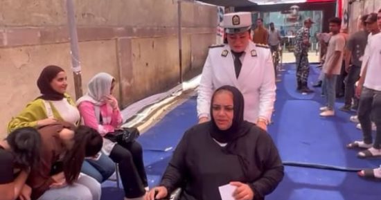 الشرطة النسائية تساعد قعيدة على الوصول إلى لجنتها الانتخابية فى حدائق القبة