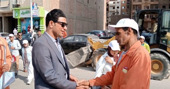 نائب محافظ سوهاج يوزع مواد غذائية وزجاجات مياه وأغطية رأس على عمال النظافة