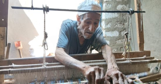 أقدم صناعها فى قنا.. العم عزت 75 عاما فوق النول الخشبي لصناعة الشال..صور
