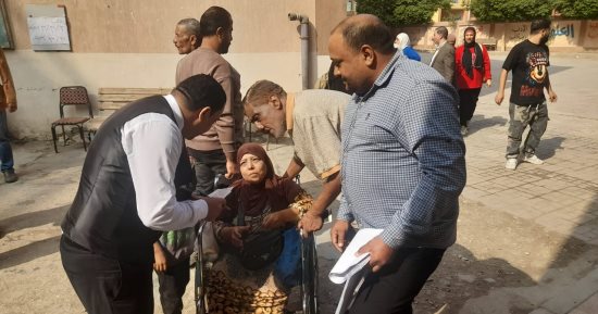 قاض بصفط اللبن يخرج من لجنته لمساعدة سيدة على كرسى متحرك.. صور