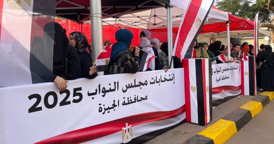 الناخبون يرسمون لوحة وطنية بأعلام مصر أمام لجان انتخابات البرلمان بالدقى 