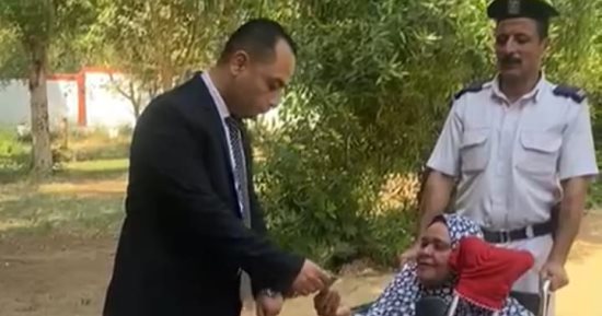 قاضٍ يساعد سيدة مسنة على الإدلاء بصوتها داخل لجنة كيما بأسوان