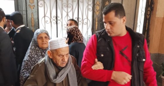 أصر على المشاركة.. موظف لجنة بالمطرية يساعد مسن فى الدخول للإدلاء بصوته.. صور