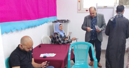 بالعزيمة والعكاز.. عجوز تتكء للتصويت بالمطرية.. والموظفون يتسابقون لمساعدتها