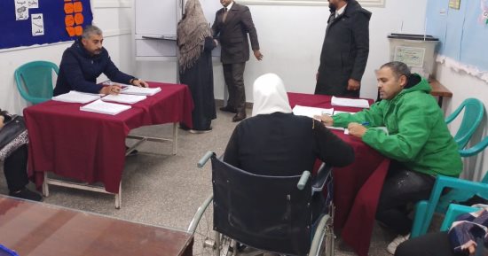 صور.. من على كرسي متحرك.. سيدة تدلى بصوتها في انتخابات البرلمان بالمطرية