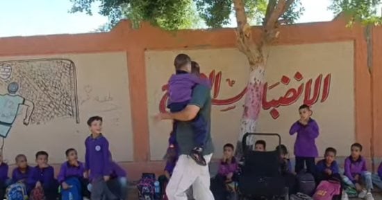 شاله وجرى بيه.. معلم يرسم البسمة بوجه تلميذ من ذوى الهمم فى سباق بقنا.. صور 