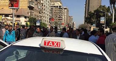 سائقو التاكسى الأبيض يحاولون ضرب ضابط مرور لتسجيله مخالفاتهم أثناء وقفتهم