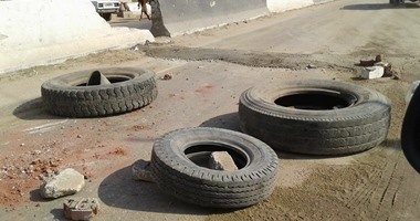 بالصور.. إلقاء إطارات سيارات بمنتصف طريق "مصر – أسيوط" يهدد حياة المارة
