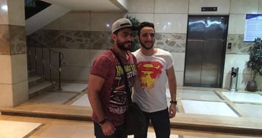 بالصور.. معجبو تامر حسنى يلتقطون الصور التذكارية معه فور وصوله مطار القاهرة