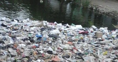 "صحافة المواطن".. القمامة تطفو على سطح إحدى الترع بقرية ميت حلفا
