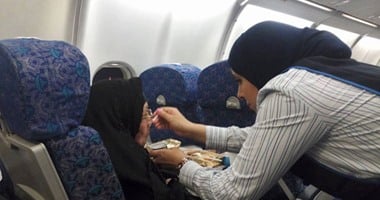 مستخدمو "فيس بوك" يتداولون صورًا لمضيفة جوية تساعد مسنة فى تناول طعامها