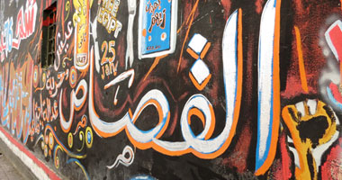 رسامو الجرافيتى يجددون الرسوم فى شارع محمد محمود