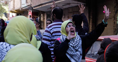 أهالى المطرية يرفعون صور "السيسى" وعلامة النصر فى وجه مسيرة الإخوان