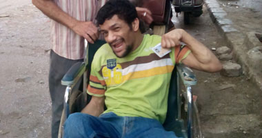 ناخب بكرسى متحرك يرفع علامة النصر عقب التصويت بالمنوفية